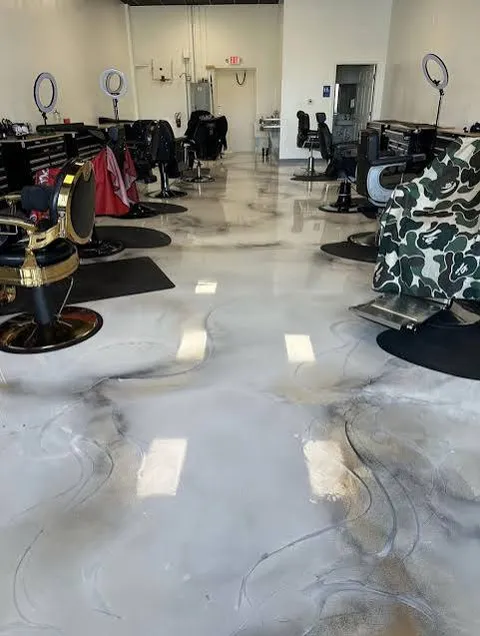 Barbershop with black barber chairs and ring lights on a white and black marbled metallic epoxy floor