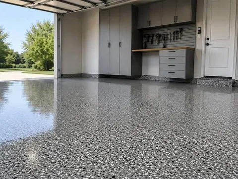 Bright two-car garage with gray cabinets and a high-gloss gray flake epoxy floor with the door open to the driveway