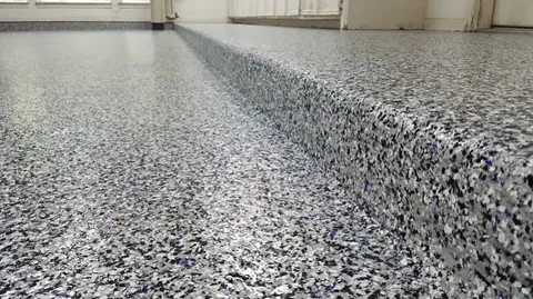 Close-up of a garage step and floor coated in black, white, gray and blue flake